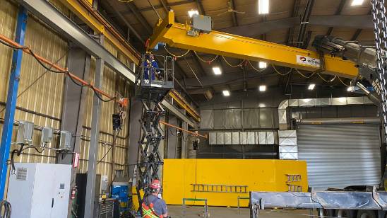 tower crane industrial, sturdy, maneuvering materials across a site, photorealistic, at a bustling urban construction area, highly detailed, city traffic in the background, crisp definition, industrial greys and blues, late afternoon lighting, shot with a 24mm lens.