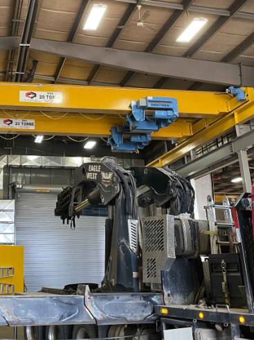 modern crane equipment, innovative, rotating its arm, photorealistic, surrounded by skyscrapers, highly detailed, workers securing loads below, fine textures, bright yellows and reds, midday sunlight, shot with a 50mm lens.