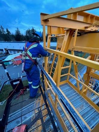 modern crane equipment, innovative, rotating its arm, photorealistic, surrounded by skyscrapers, highly detailed, workers securing loads below, fine textures, bright yellows and reds, midday sunlight, shot with a 50mm lens.